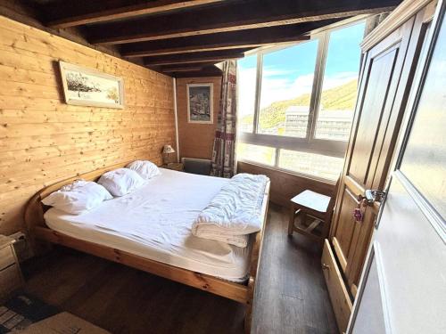 une chambre avec un lit dans une pièce avec une fenêtre dans l'établissement Résidence Grande Masse - Duplex mezzanine 8 personnes aux Ménuires MAE-4384, aux Menuires