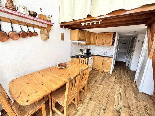 - une cuisine avec une table en bois et des placards en bois dans l'établissement Résidence Grande Masse - Duplex mezzanine 8 personnes aux Ménuires MAE-4384, aux Menuires