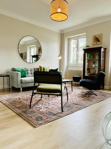 un salon avec une chaise et un miroir dans l'établissement Chez Jean ! Au pied du vignoble, à 5 min de Colmar, à Ingersheim