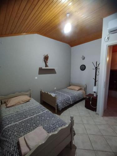 a bedroom with two beds and a wooden ceiling at Seaview Maisonette Paradise in Pláka