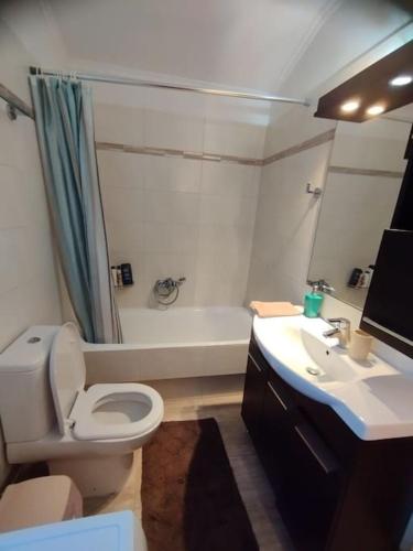 a bathroom with a toilet and a sink and a tub at Seaview Maisonette Paradise in Pláka
