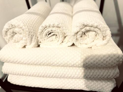 a stack of white towels sitting on a chair at Apartament Zielony Stół in Gniezno
