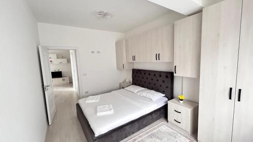 a small bedroom with a bed and white cabinets at Dany luxury apartament in Rădăuţi