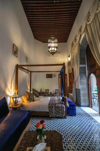 a bedroom with a large bed and a chandelier at Riad Louna Fes & Spa in Fès
