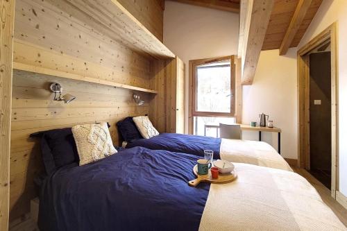 due letti in una stanza con pareti in legno di Résidence Le Bettex - Chalet TY MENEZ MAE-9634 a Praranger