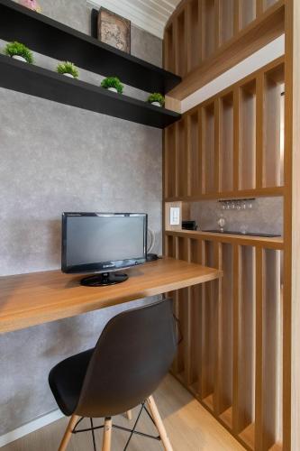 a desk with a monitor and a chair in a room at 0610 - Studio alto padrão in Guarulhos