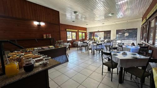 a dining room with tables and chairs in a restaurant at Pousada Canela Garden in Canela