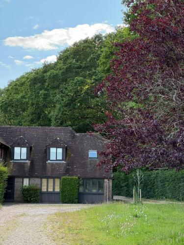 a brick house with a hill in the background at The Annex, Westerlands, Graffham in Graffham