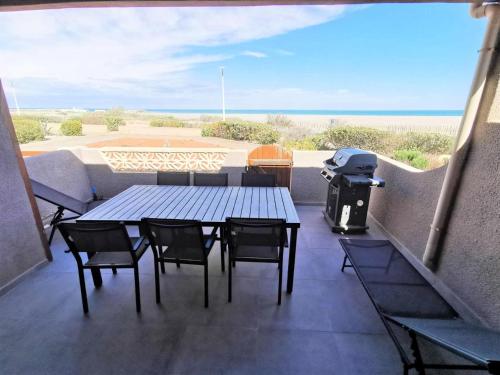 d'une table et de chaises sur un balcon avec barbecue. dans l'établissement Résidence Grande Bleue - VILLA T2 MEZZANINE 6 couchages PORT LEUCATE MAE-0464, à Leucate