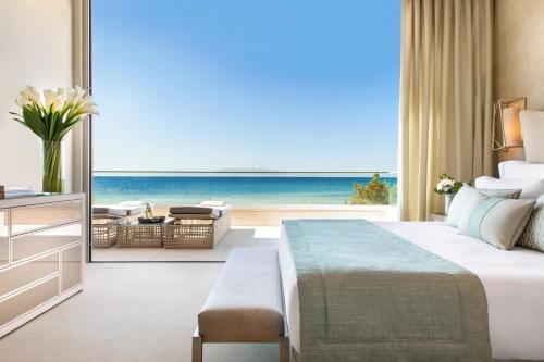 a hotel room with a bed and a view of the ocean at Sani Dunes in Sani Beach