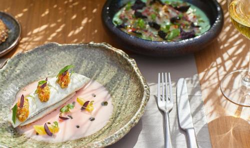 a table with a plate of food and a bowl of salad at Sani Dunes in Sani Beach