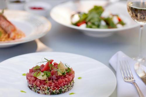 a white plate with a food dish on a table at Sani Dunes in Sani Beach