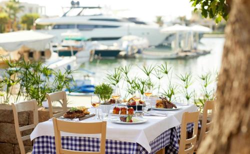 a table with plates of food and wine and a marina at Sani Dunes in Sani Beach