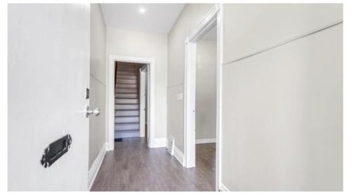 an empty room with a door and a hallway at H men's dormitory in Hamilton