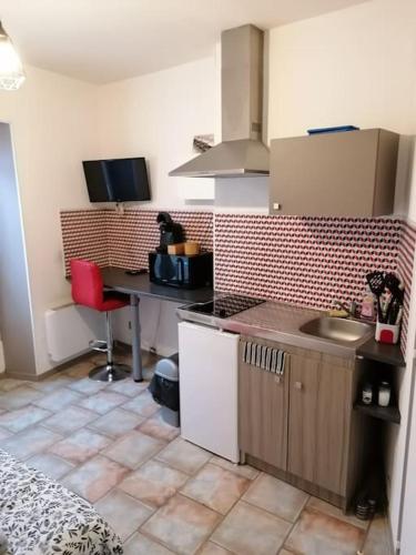 - une cuisine avec un évier et un bureau dans la chambre dans l'établissement Le Petit Cosy 2e étage 15 m2, à Niort