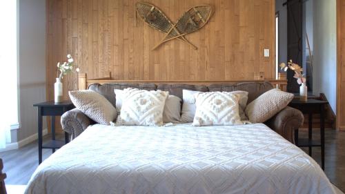 Exclusive Waterfront Cottage في Combermere: غرفة نوم بها سرير وجدار خشبي