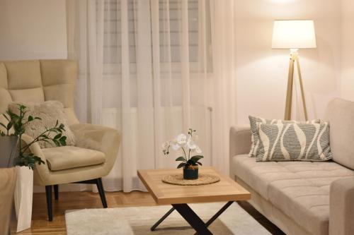 a living room with a couch and a chair and a table at Apartman Vasilisa in Novi Sad