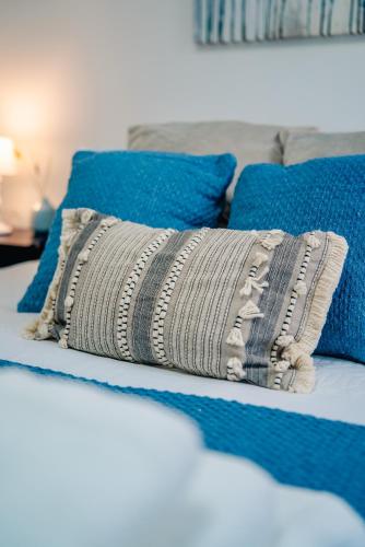 a bed with a blanket on it with blue pillows at Amias Homes in Cardiff