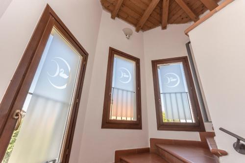 a room with three windows and a staircase at Hotel Residence - Il Giardino del Cigno in Latisana