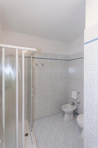 a bathroom with a shower and a toilet and a sink at Hotel Residence - Il Giardino del Cigno in Latisana
