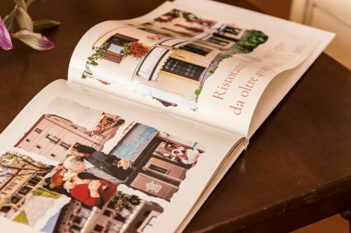 two pages of a magazine on top of a table at Hotel Residence - Il Giardino del Cigno in Latisana