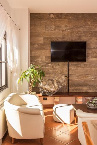 a living room with a tv on a wooden wall at Hotel Residence - Il Giardino del Cigno in Latisana