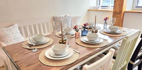 a wooden table with plates and cups on it at Apartment Südwind - Beautiful premium apartment with 2 bedrooms near Rhine Falls & Zurich Airport in Klettgau in Klettgau