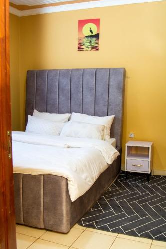 a bed with a large headboard in a room at MJ-Homes Eldoret 2 Bedroom in Eldoret
