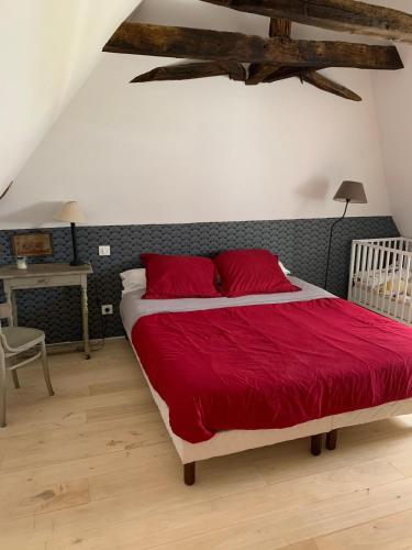 a bedroom with a large bed with red sheets at La Sautie in Bars