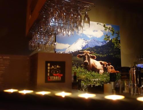 a large picture of a cow on the wall of a bar at Hotel L'Etable in Les Crosets