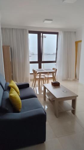 Una sala de estar con un sofá azul y una mesa. en Casa Mina, en Las Palmas de Gran Canaria