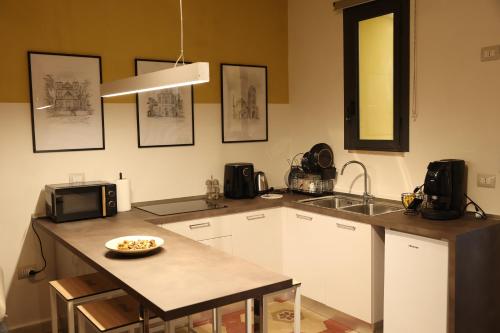 a kitchen with a counter with a microwave and a sink at Grotta Cimabue in Caserta