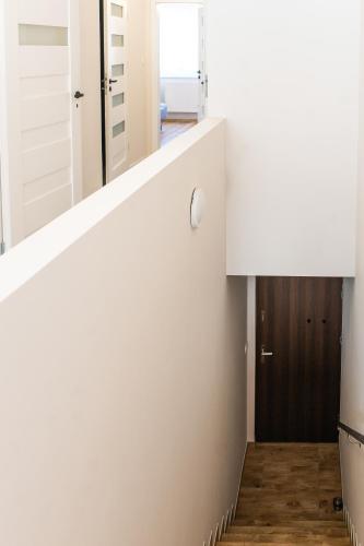 a staircase in a house with white walls and wooden floors at Apartament Gościnny Czempion in Gniezno
