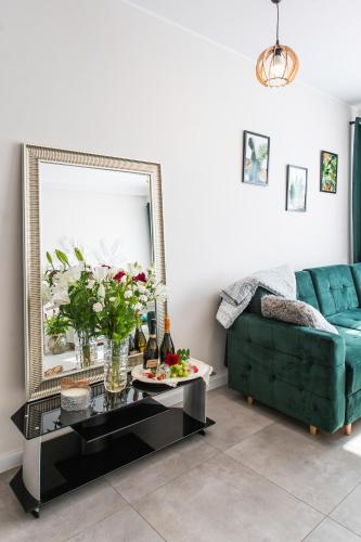 a living room with a green couch and a table at Apartament Gościnny Czempion in Gniezno