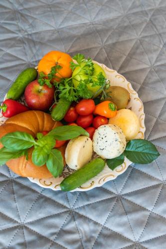 a plate of fruits and vegetables on a table at Apartament Gościnny Czempion in Gniezno
