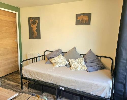 un lit avec des oreillers dessus dans une chambre dans l'établissement Joli Studio indépendant à 20 min de Paris, à Villennes-sur-Seine