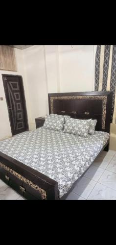 a bedroom with a bed with a wooden headboard at Canal Enclave, Canal Road West in Lahore