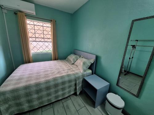 a small bedroom with a bed and a mirror at Ackee Green Rental - 3 beds large apartment or 2 beds modern apartment in Gros Islet