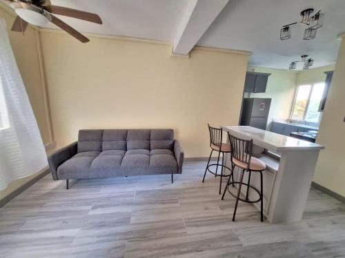 a living room with a couch and a table at Ackee Green Rental - 3 beds large apartment or 2 beds modern apartment in Gros Islet