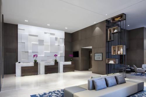 a living room with a couch and a counter at Courtyard by Marriott Tianjin Hongqiao in Tianjin