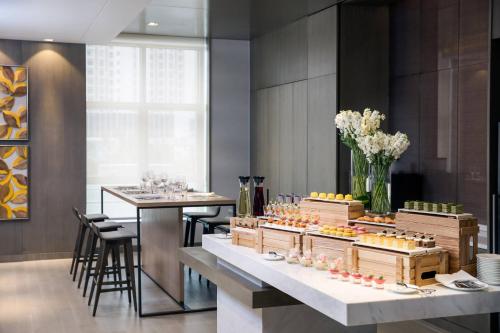 a restaurant with two tables and a counter with food at Courtyard by Marriott Tianjin Hongqiao in Tianjin