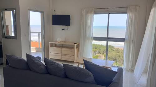 a living room with a couch and a view of the ocean at Rest Departamento con vista al mar in San Bernardo