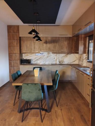 a kitchen with a wooden table and chairs at Luxury Apartments in Kostakioí