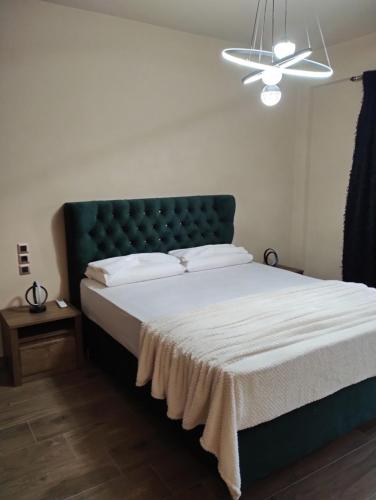 a bedroom with a bed with a green headboard at Luxury Apartments in Kostakioí