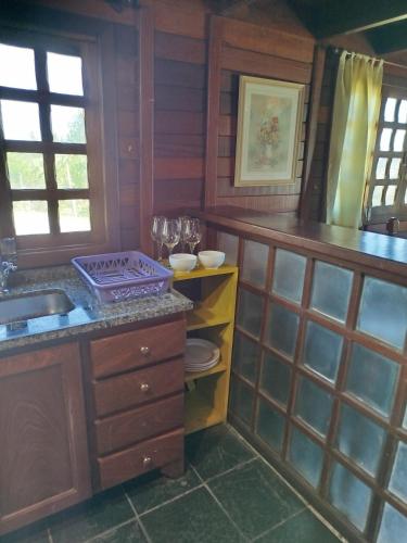 a kitchen with a sink and a counter top at Cabanas La Suisse in Campos do Jordão
