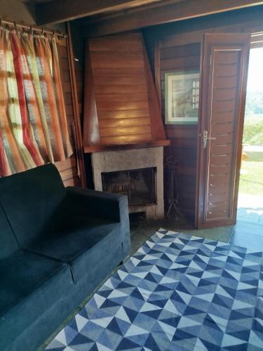 a living room with a couch and a fireplace at Cabanas La Suisse in Campos do Jordão