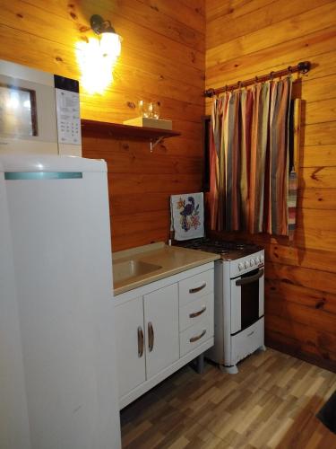 a kitchen with a sink and a stove at Cabanas La Suisse in Campos do Jordão