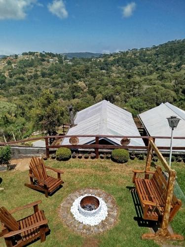 a patio with two chairs and a fire pit at Cabanas La Suisse in Campos do Jordão