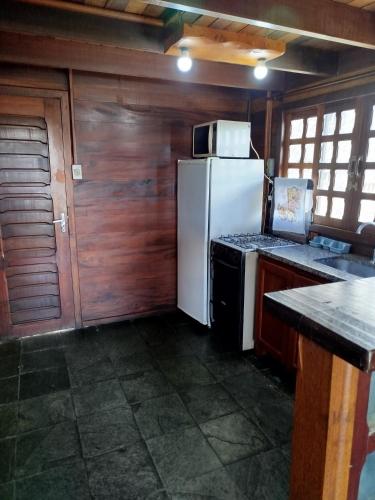 a kitchen with a white refrigerator and a stove at Cabanas La Suisse in Campos do Jordão