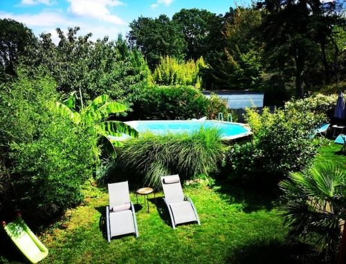 2 chaises, une table et une piscine dans l'établissement Le Studio Charmant à 20min de Paris, à Villennes-sur-Seine
